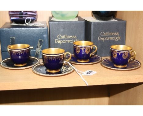 TWO PAIRS OF SIMILAR ROYAL WORCESTER CABINET COFFEE CUPS AND SAUCERS, decorated with gilt borders on a blue ground, with gilt