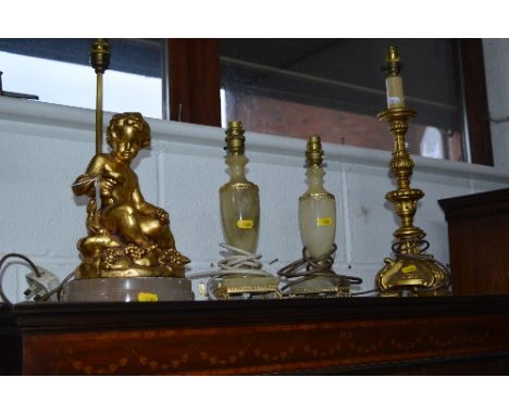 A TABLE LAMP OF A CHERUB ON A ONYX BASE, three other table lamps and a circular wall mirror and a umbrella stand with content