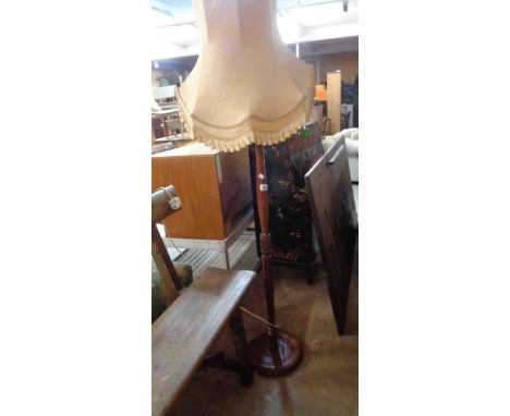 A vintage stained wood standard lamp, set on turned pillar and circular base - sold with shade