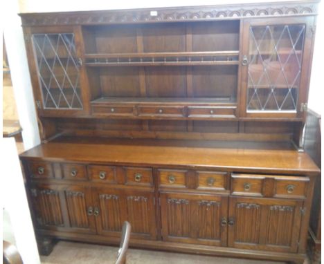 A 1.92m vintage oak two part dresser with central two shelf open plate rack, flanking leaded glazed cupboard doors and spice 