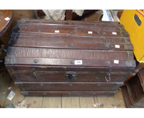 A 67cm antique dome-top travelling trunk with iron and wood bound weather coating and flanking drop handles