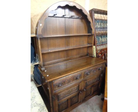 A 1.22m Old Charm stained oak two part dresser with dome-top two shelf open plate rack, two frieze drawers and pair of panell