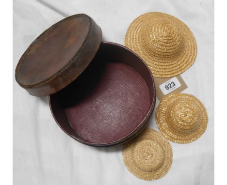 A vintage leather collar box containing three straw doll's hats