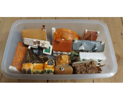 A tub containing a quantity of miniature ceramic house models of various form and maker