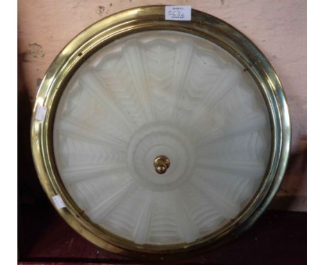 A modern brassed metal ceiling light with moulded glass shade