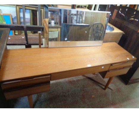 A 1.52m retro teak effect kneehole dressing table with detached oblong mirror, central blind frieze drawer and four flanking 