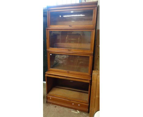 An 86cm early 20th Century Globe Wernicke light oak four section modular bookcase with cornice and plinth base, all with orig