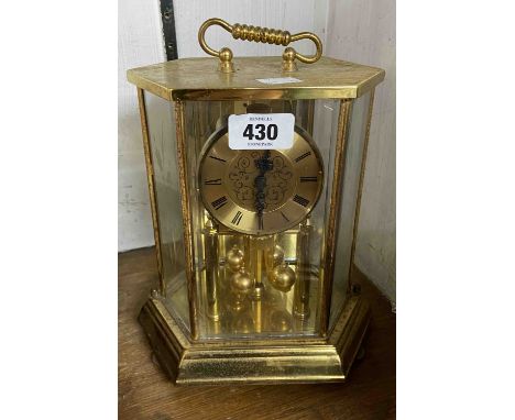 A modern anniversary clock with faceted case and ball pendulum