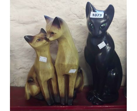 A large ceramic figurine, depicting a stylised seated cat with painted finish - sold with a similar resin figure, depicting t