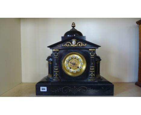 A black slate architectural mantle clock missing its hour hand but ticks and chimes