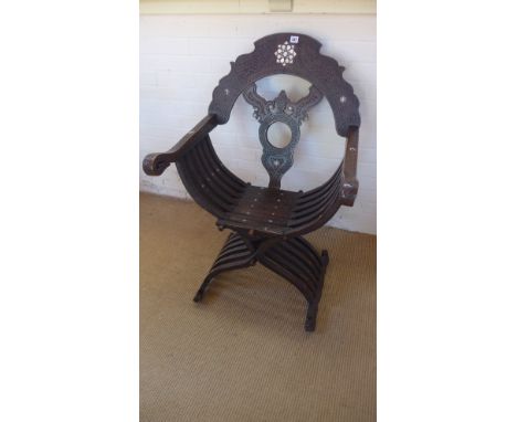 An Arabic inspired design chair the hardwood frame profusely carved and with mother of pearl inlay pierced splat over solid s