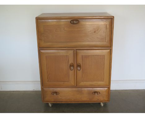 An Ercol blonde cabinet fall front over two doors above drawers - 82cm x 44cm x 110cm high