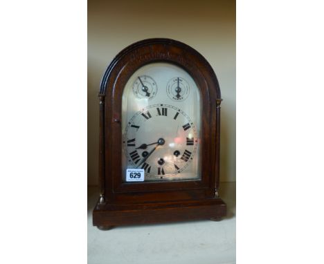 An 8 day mantle clock with quarter chimes in an oak case