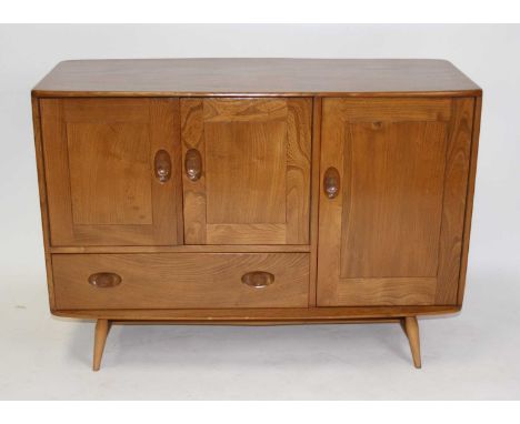 An Ercol light elm Windsor compact sideboard, model No.366, having an arrangement of three cupboard doors and single lower dr