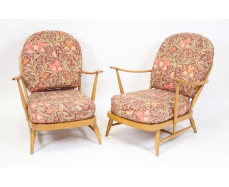A pair of 1960s Ercol light elm stickback open armchairs, model 203, each with floral patterned cushions and webbed seats, w.