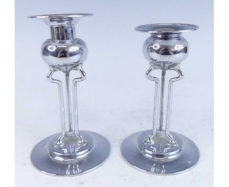 A near-pair of Art Nouveau silver candlesticks, each with bulbous sconce on wired shaped triform supports, to circular steppe