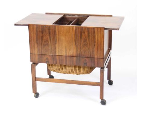 A 1960s Danish rosewood sewing table, of plain rectangular form, with twin sliding and folding top surface enclosing a remove