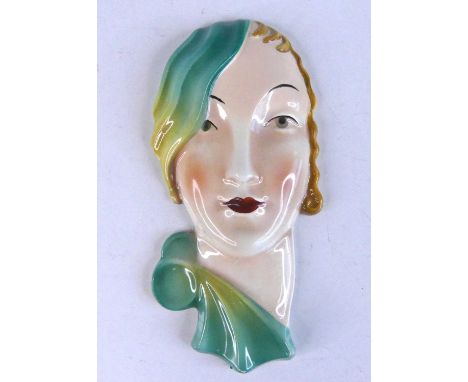 A small Continental Art Deco pottery stylised face mask of a woman, underglaze painted, printed mark and impress numbered 205