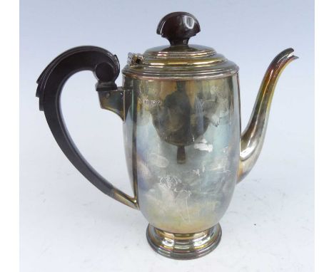An Art Deco silver coffee pot having a stylised stepped bakelite finial and scroll handle with hinged cover to plain body and