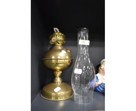 A vintage brass oil lamp having glass chimney.