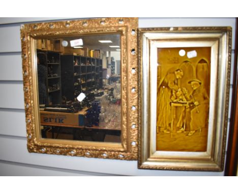 A gilt and gesso framed hall way mirror and ceramic relief wall tile of priest and parson smoking pipe
