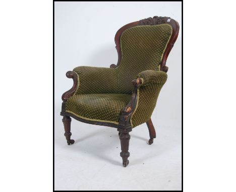 A Victorian mahogany spoon back armchair raised on reeded tapered legs with brown ceramic castors upholstered seat and back r