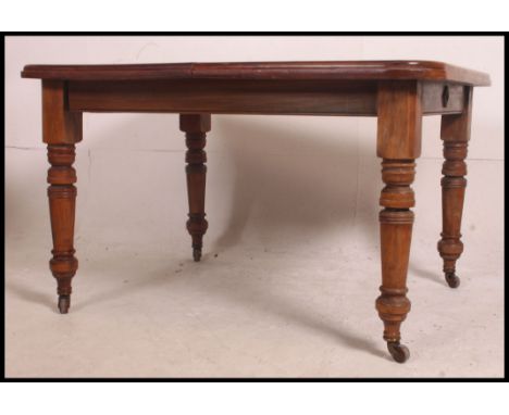 A 19th century mahogany wind out dining table of good quality having an extra leaf. The table being raised on turned legs wit