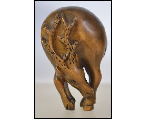 A 20th century carved wooden Japanese netsuke in the form of a deer. having twin pierced holes - unsigned. Weight 13.7g. Meas