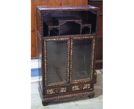 An Oriental hardwood side cabinet, the top with open recess below two glazed and mother of pearl inset doors and two drawers 