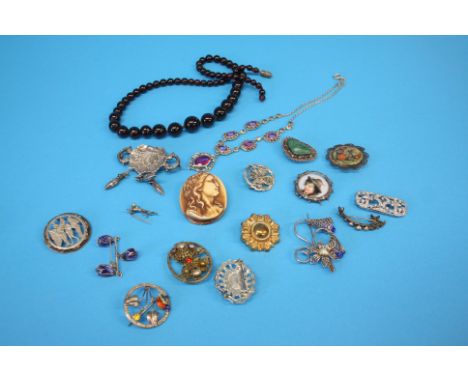 A white metal marcasite and ruby coloured necklace, amber coloured bead necklace and sixteen brooches, various.