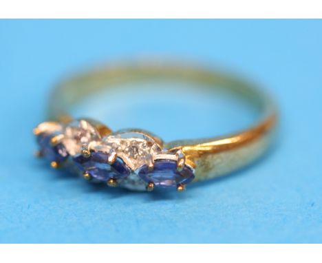 A 9ct gold ring set with three blue sapphires and four diamonds.  Ring size N.