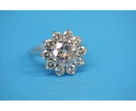 An 18ct white gold diamond cluster ring with central brilliant cut diamond, approx. 2.35 carats, clarity S1, coloured H, surr