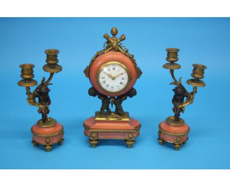 A small French clock garniture, the clock with enamelled circular dial supported by two putti and a pair of winged putti two 