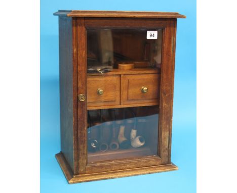 A wall mounted pipe display cabinet, a mahogany pipe/tobacco cabinet and a collection of pipes.