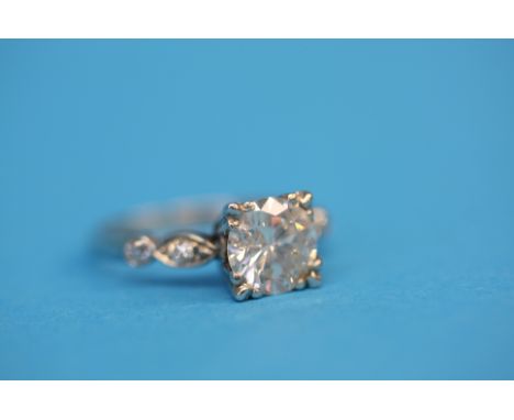 A solitaire diamond ring, approximately 1.9cts on diamond shoulders in platinum.