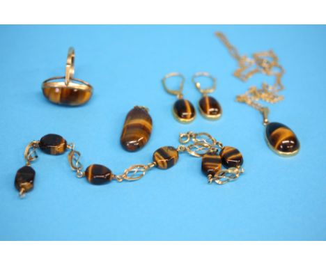 A 9ct gold Tiger's eye ring, a Tiger's eye bracelet, pair of earrings and two pendants.