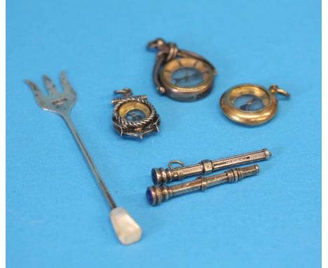 A small silver pickle fork, three watch fob compasses and two silver propelling pencils.