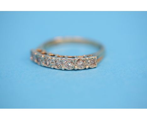 A 9ct gold eternity ring set with seven diamonds.  Ring size Q.
