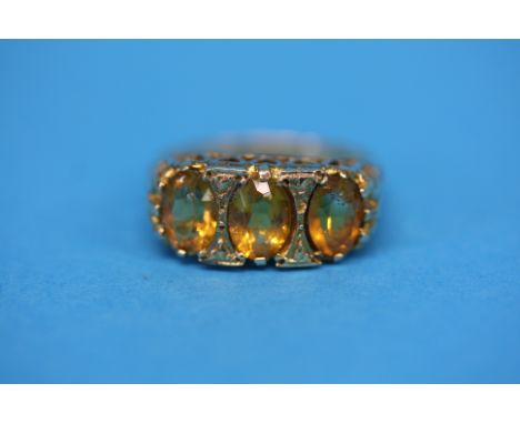 A 9ct gold ring set with three Citrines.  Ring size O.