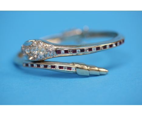 A 14ct white gold diamond and ruby set hinged snake bangle.  The snake's head with approx. 1.76 carat of diamonds, clarity VS