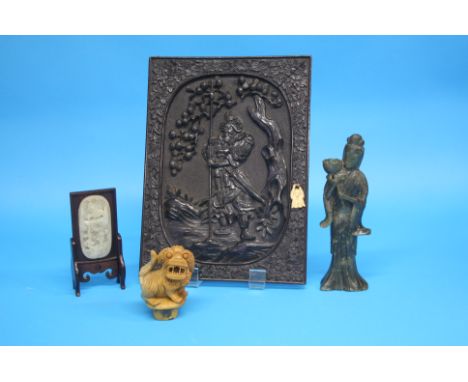 A Chinese carved wood panel decorated with a warrior; a 20th century carved jade inset panel on a stand; a carved jade figure
