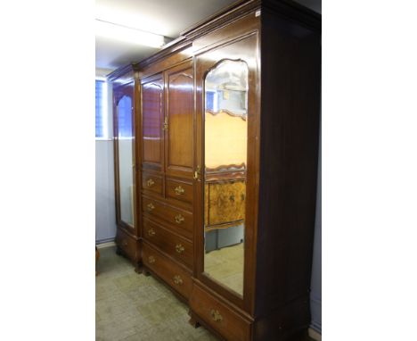 A Gillows of Lancaster oak breakfront Gentleman's wardrobe with dentil cornice below two panelled doors opening to reveal lin