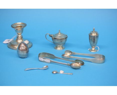 Two pairs of silver sugar tongs, a silver candlestick, silver condiments etc.