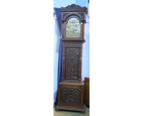 A carved oak long case clock by Thompson of London with engraved brass dial silvered chapter ring, 8 day movement and subsidi