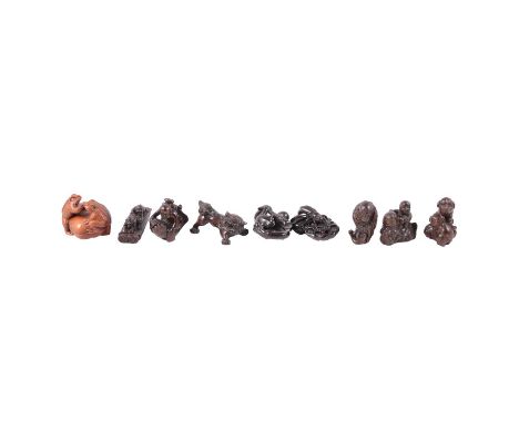 Nine Japanese carved wood netsuke, including two toads, boy with fish, monkeys, kylin, etc., all with inset mother of pearl s