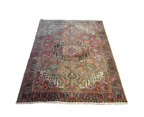 Large Heriz carpet, large central medallion against a strawberry red field filled with flower heads, deep spandrels and enclo