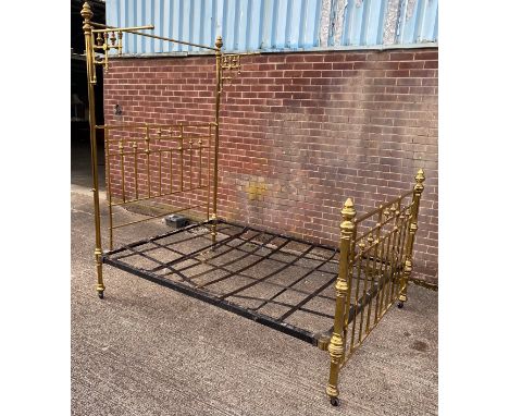 Antique brass double bed frame with curtain rails to the headboard, all castors present, two brass bolts missing and straps p