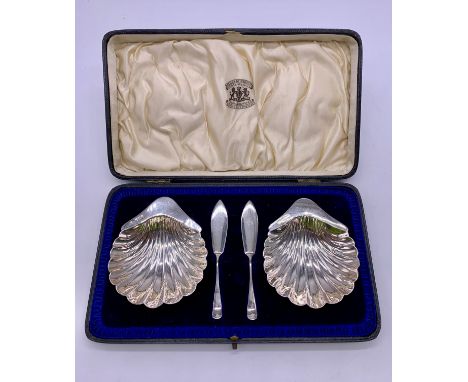 Pair of sterling silver shell shaped butter dishes and knives, George V period Sheffield 1923, makers mark GH for Harrison Br