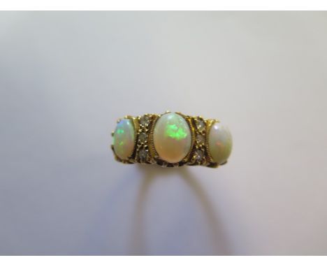 An 18ct yellow gold three stone opal and diamond ring, size O, approx 5.8 grams, in good condition, marked 18ct 