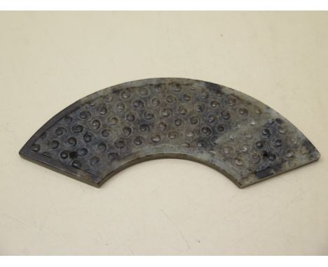 A carved jade arc shaped pendant carved with Archaic swirl shaped studs, 10.5cm long, in good condition 